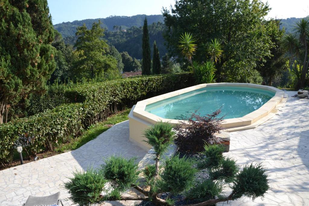 une piscine au milieu d'un jardin dans l'établissement Villa Costa Medea, à Camaiore