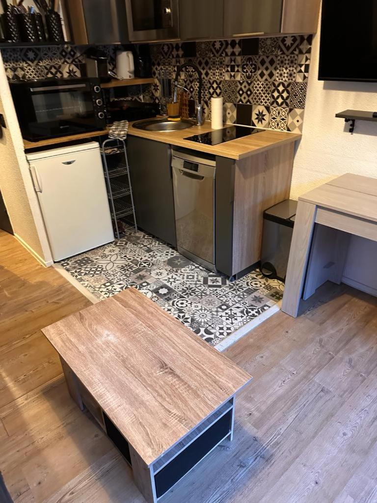- une cuisine avec des tables en bois et un comptoir dans l'établissement Valfrejus Studio 19m2 cosy 60 m des pistes draps non compris, à Modane