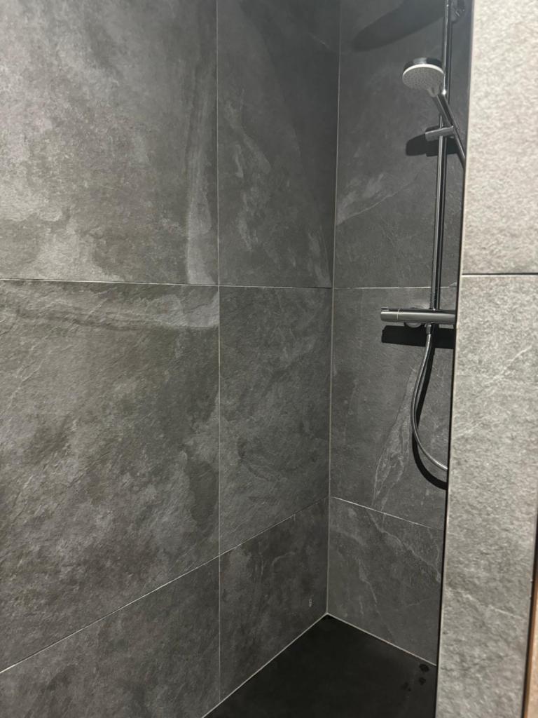 une salle de bain avec douche aux carreaux gris dans l'établissement TIGNES - VAL D'ISERE - SKI au PIED, à Tignes