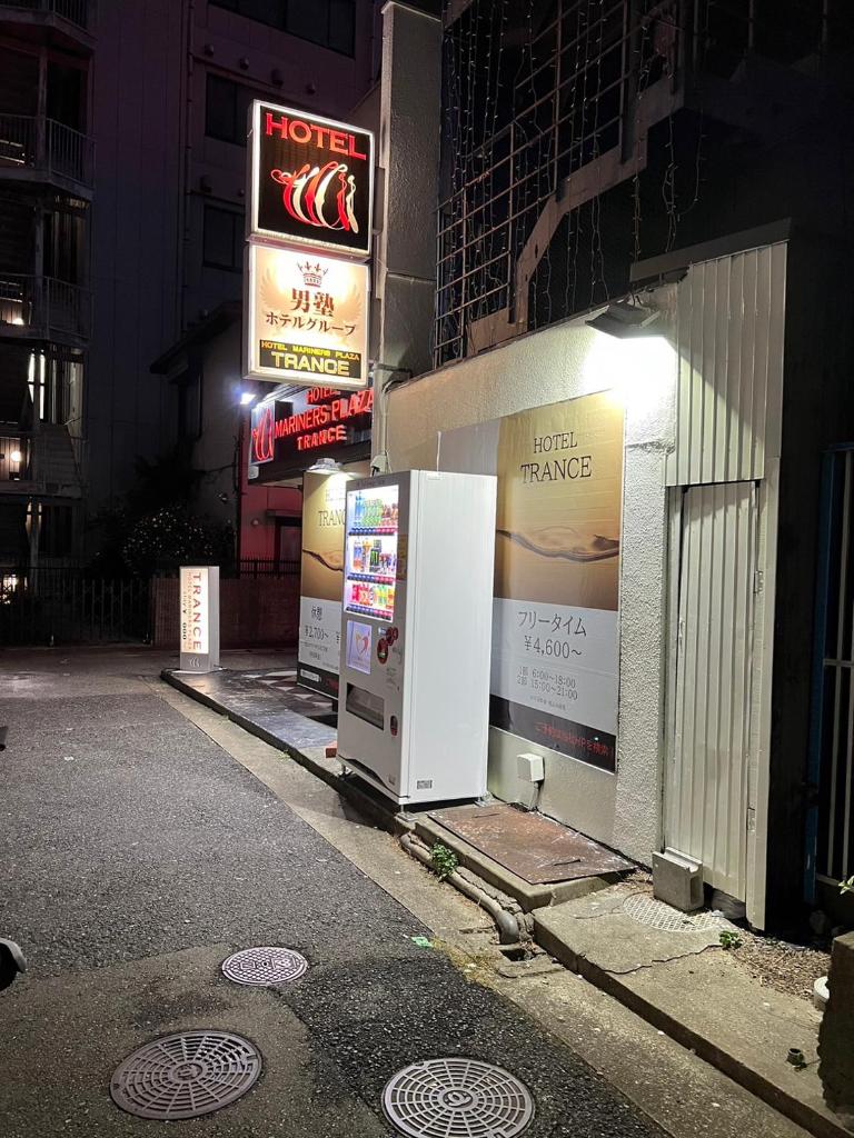 - deux réfrigérateurs sur le côté d'un bâtiment la nuit dans l'établissement トランス 神戸三宮男塾ホテルグループ, à Kobe