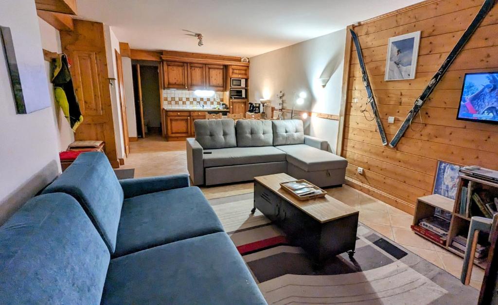un salon avec un canapé bleu et une table dans l'établissement Morillon 1100 Skis aux pieds, à Morillon 14 autres photos