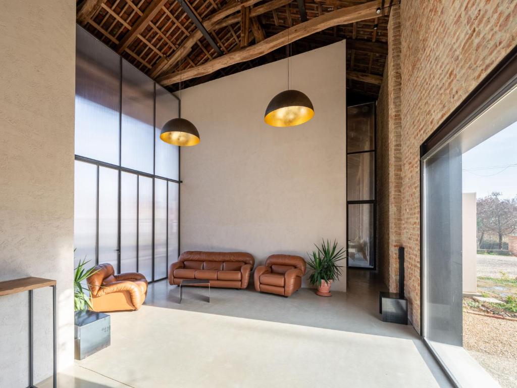 Elle comprend un salon doté d'un mobilier en cuir et de grandes fenêtres. dans l'établissement Villa We Rural by Interhome, à Poirino 43 autres photos