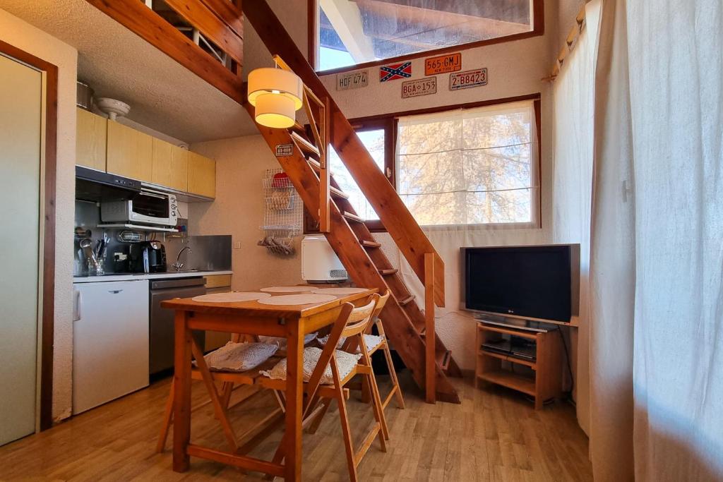 une cuisine avec une table et un escalier dans une petite maison dans l'établissement Apartment 6 people in the heart of Valberg resort, à Valberg