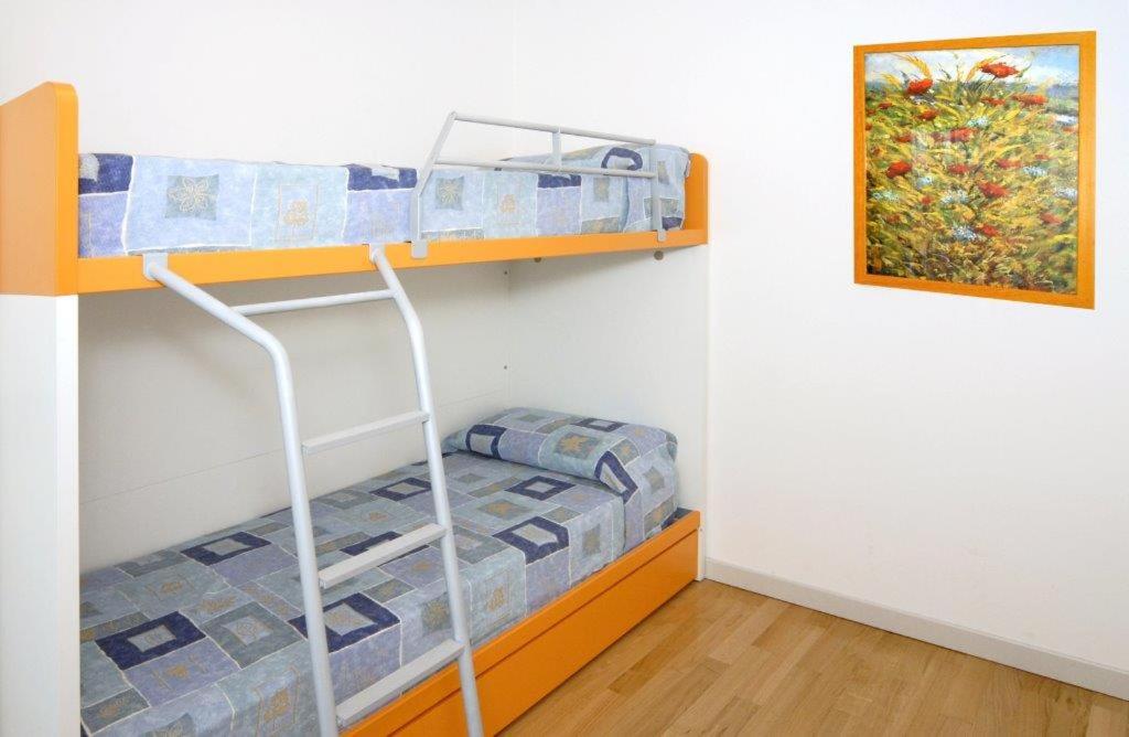 Ce dortoir comprend 2 lits superposés et un tableau. dans l'établissement Dune Dependance, à Bibione