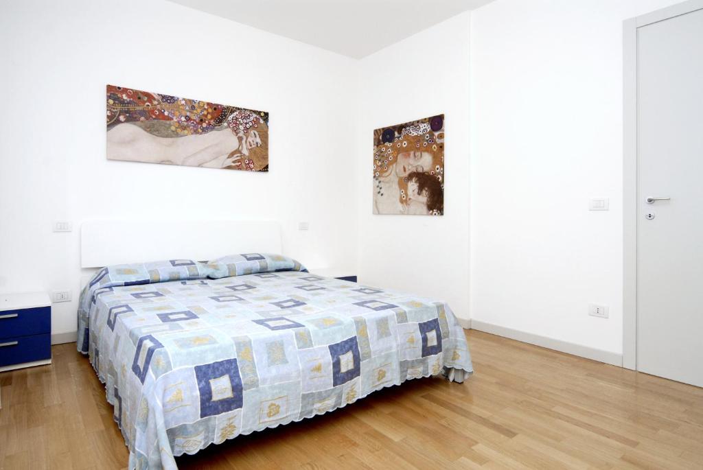 une chambre avec un lit et deux tableaux au mur dans l'établissement Dune Dependance, à Bibione