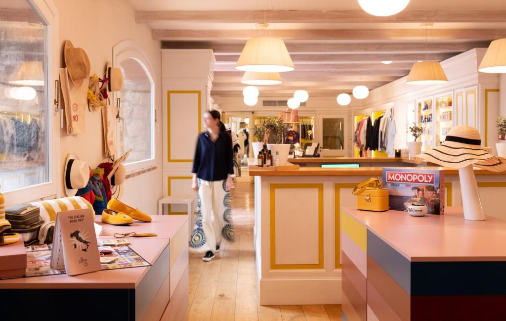 une femme traverse un magasin dans l'établissement Il Pellicano, à Porto Ercole 142 autres photos