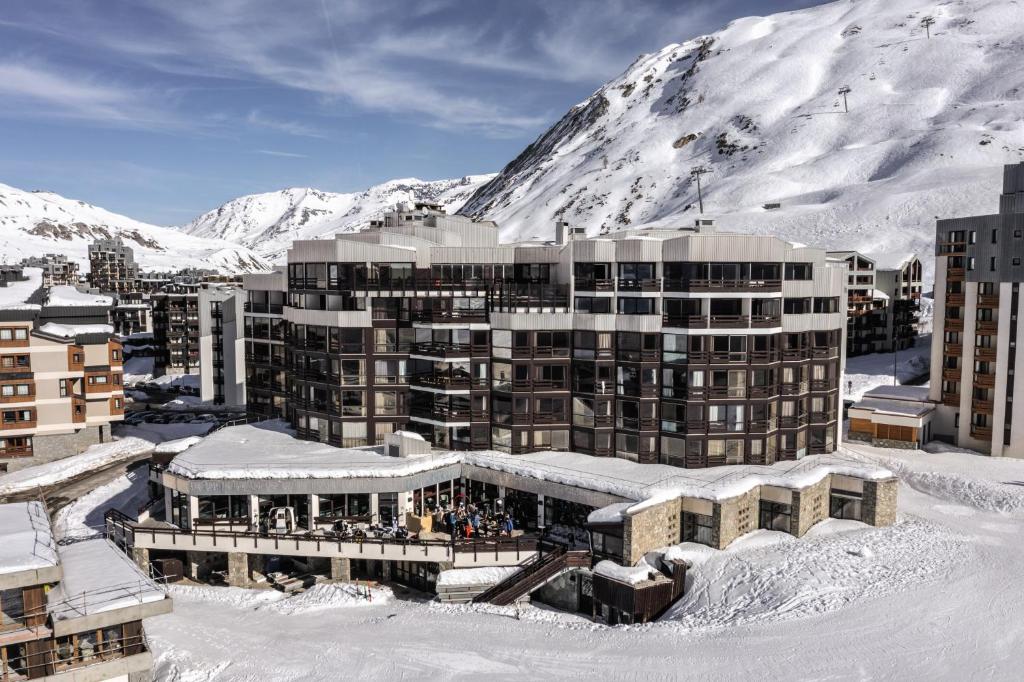 un bâtiment dans la neige devant une montagne dans l'établissement Belambra Clubs Tignes Val Claret, à Tignes
