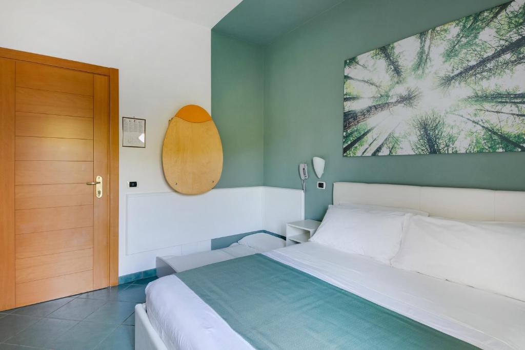 une chambre avec un lit et une porte en bois dans l'établissement Pinetina Mare Baby Family Hotel, à Cervia