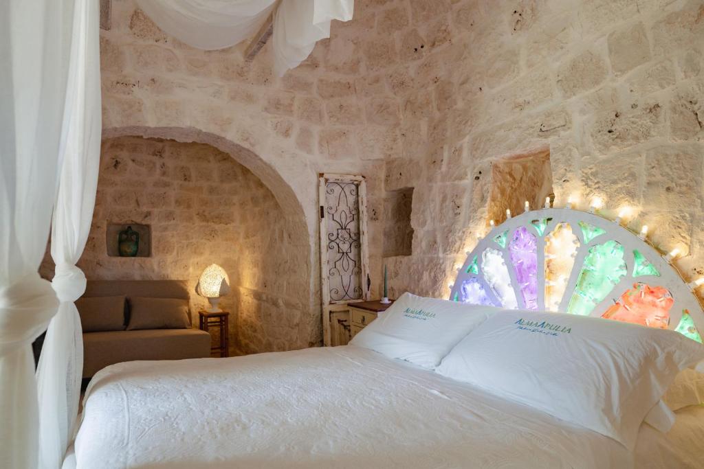 une chambre avec un lit blanc et une fenêtre dans l'établissement Alma Apulia " Italian Dolce Vita", à Ostuni