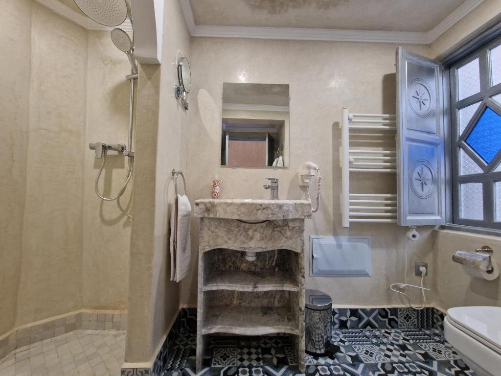 une salle de bain avec un lavabo en pierre et une douche dans l'établissement Riad Explore, à Marrakech 25 autres photos