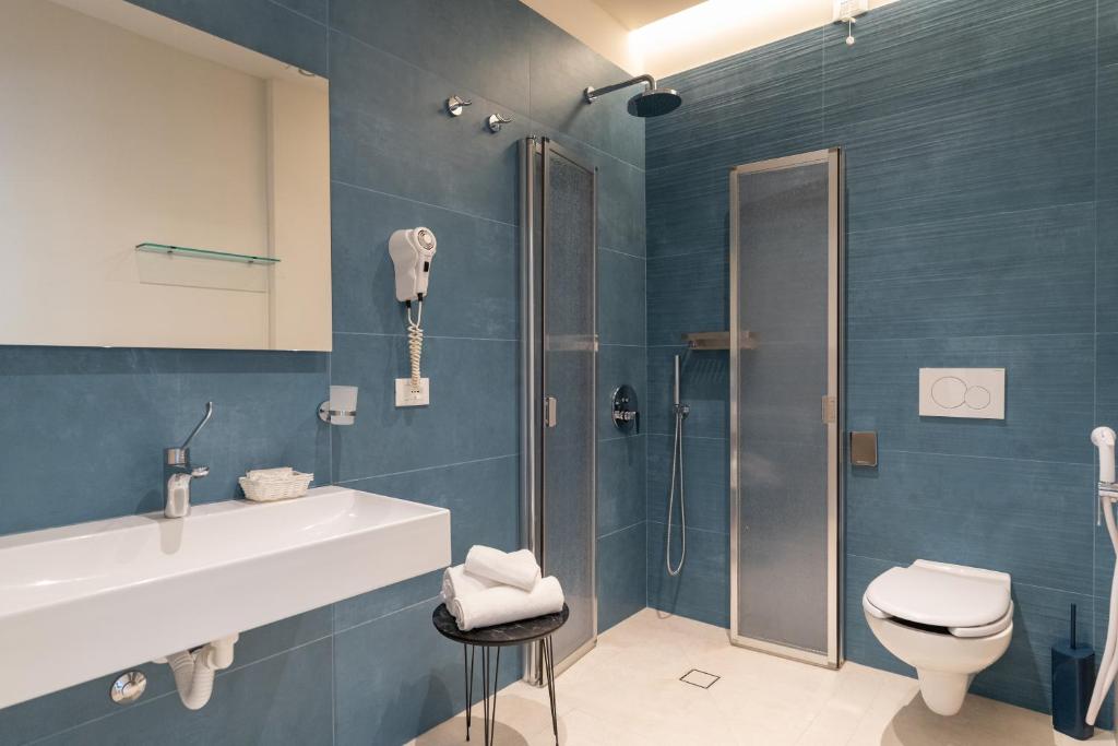 une salle de bain avec douche, lavabo et toilettes dans l'établissement Miomar Beach Hotel, à Cesenatico