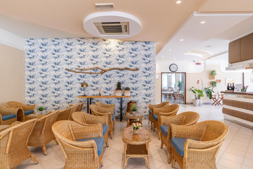 une salle d'attente avec des chaises et des tables en osier dans l'établissement Miomar Beach Hotel, à Cesenatico