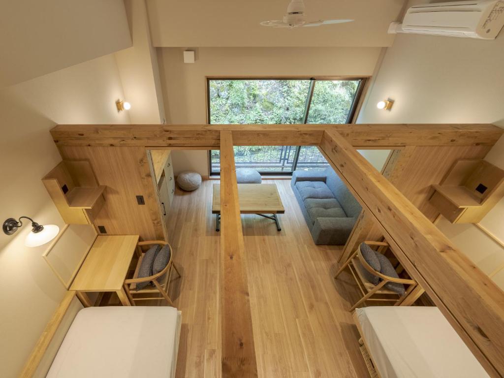une chambre avec un escalier, des chaises et une table dans l'établissement Hishino Onsen Tokiwakan, à Komoro