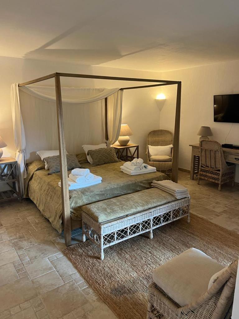 une chambre avec un lit à baldaquin dans l'établissement Villa Acula, à Cannigione