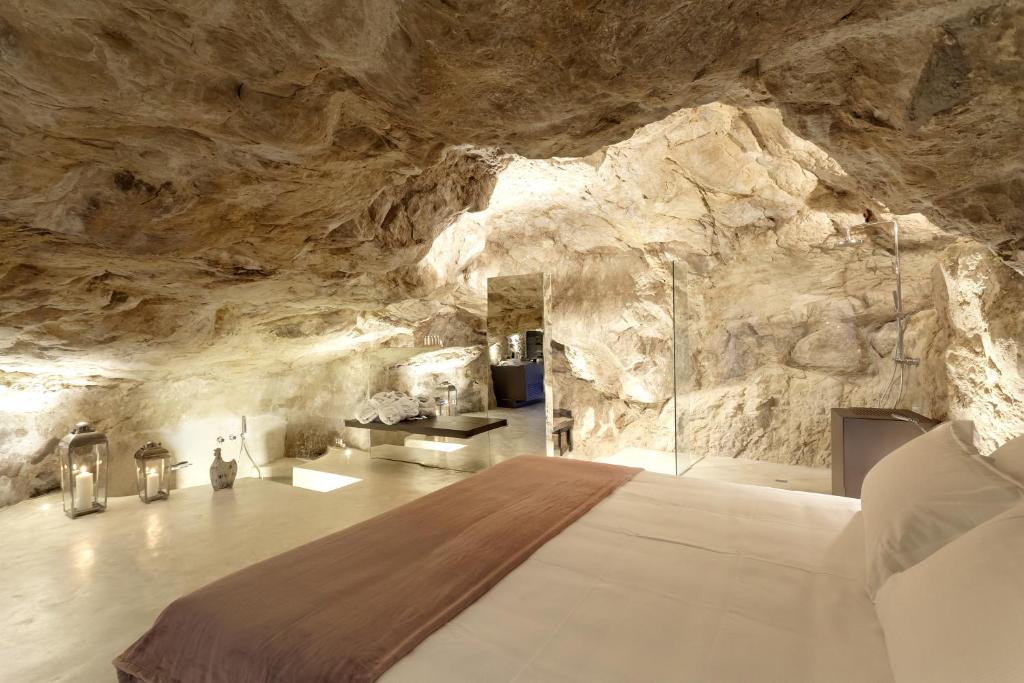 une chambre dans une grotte avec un lit dedans dans l'établissement Locanda Don Serafino Historical Boutique Hotel, à Raguse