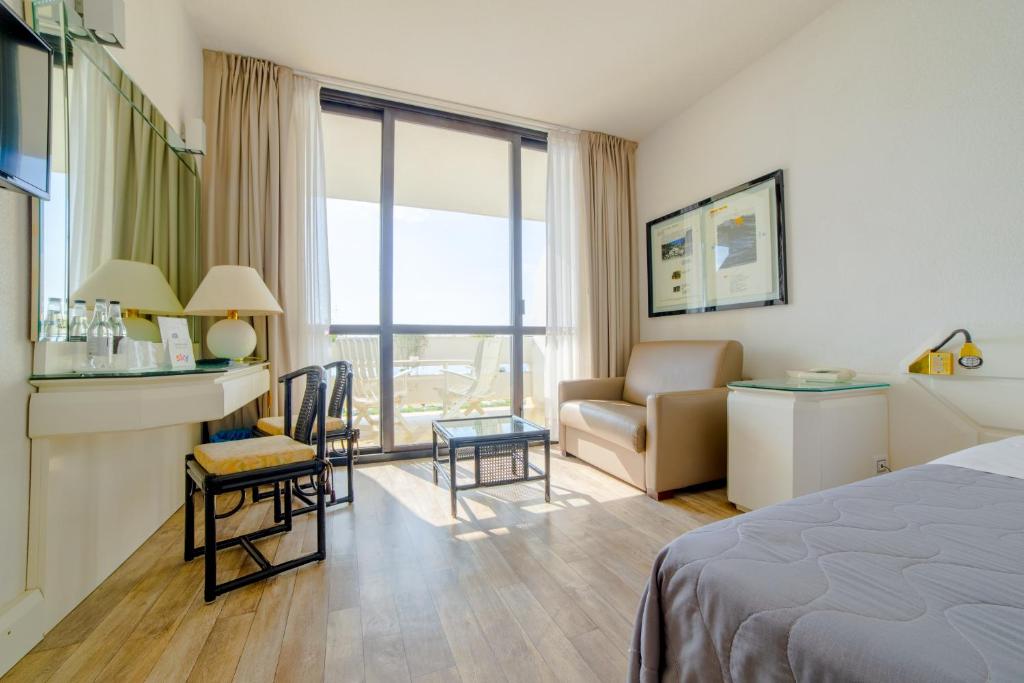 une chambre d'hôtel avec un lit, un bureau et une chaise dans l'établissement Grand Hotel Pianeta Maratea Resort, à Maratea