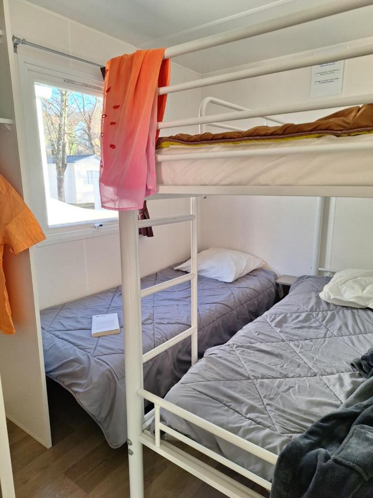 une chambre avec deux lits superposés et une fenêtre dans l'établissement Les rives d'Auzon, à Lavilledieu