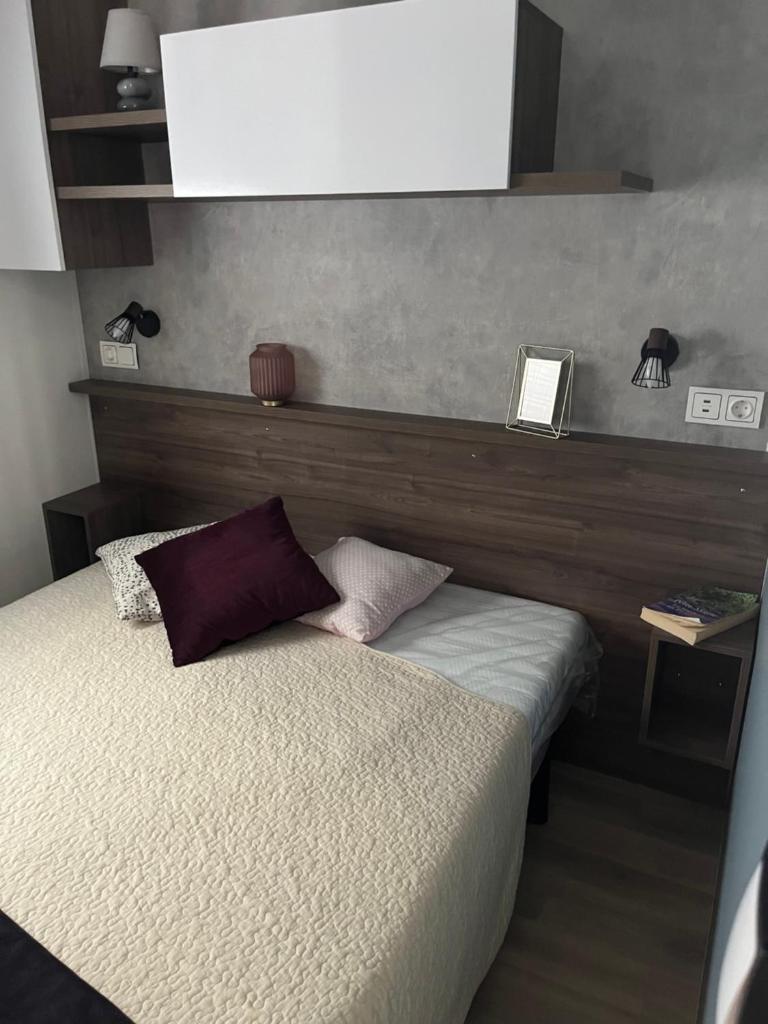 une chambre avec un lit avec une tête de lit en bois dans l'établissement Mobile home Bora Bora, à Gastes 11 autres photos
