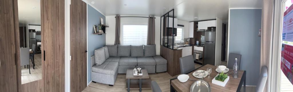 un salon avec un canapé gris et une table dans l'établissement Mobile home Bora Bora, à Gastes