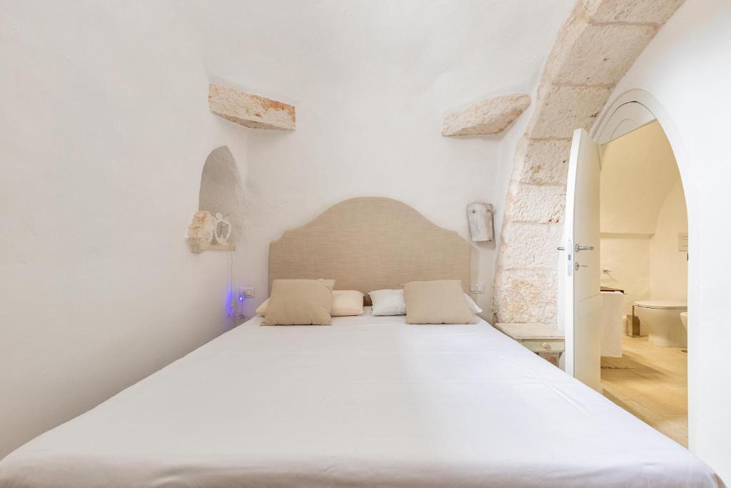 une chambre avec un grand lit blanc avec deux oreillers dans l'établissement Casal 800 by Perle di Puglia, à Ostuni 62 autres photos