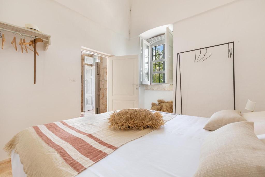 - une chambre blanche avec un lit doté d'une botte de foin dans l'établissement Casal 800 by Perle di Puglia, à Ostuni