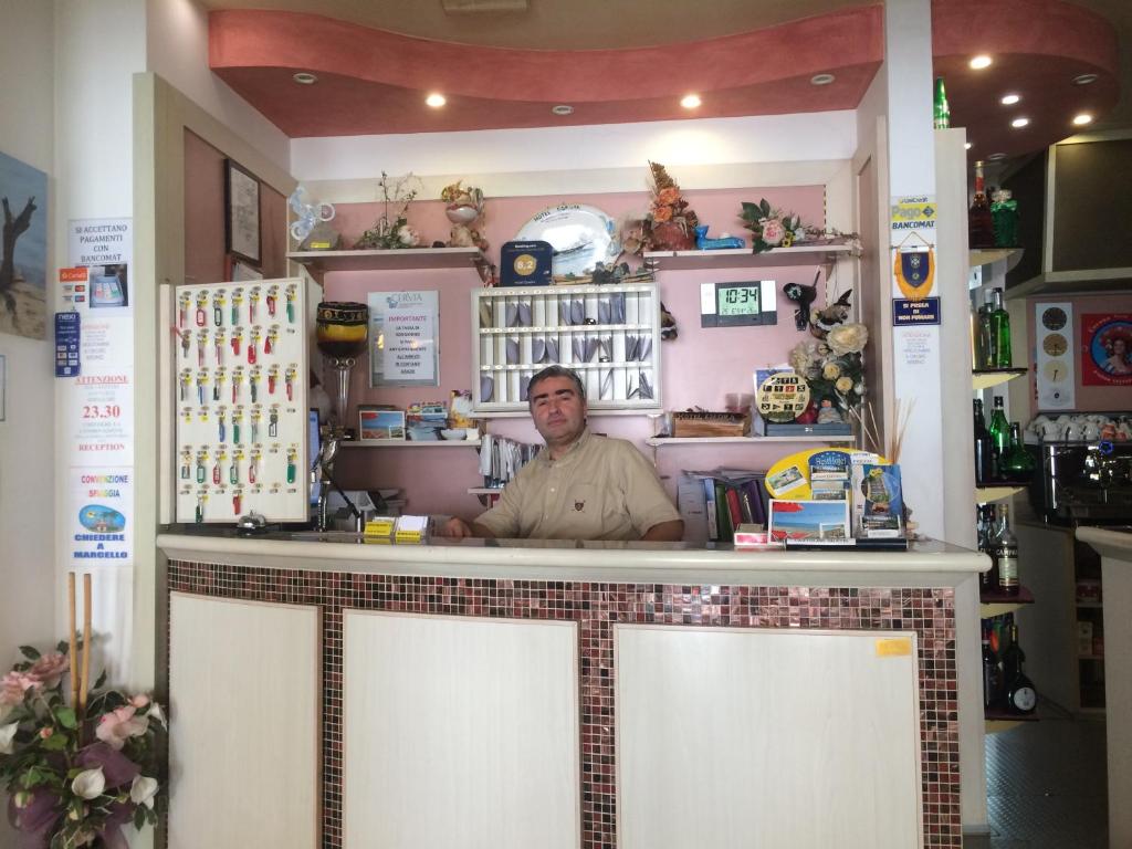 un homme debout derrière le comptoir d'un magasin dans l'établissement Hotel Esedra, à Milano Marittima