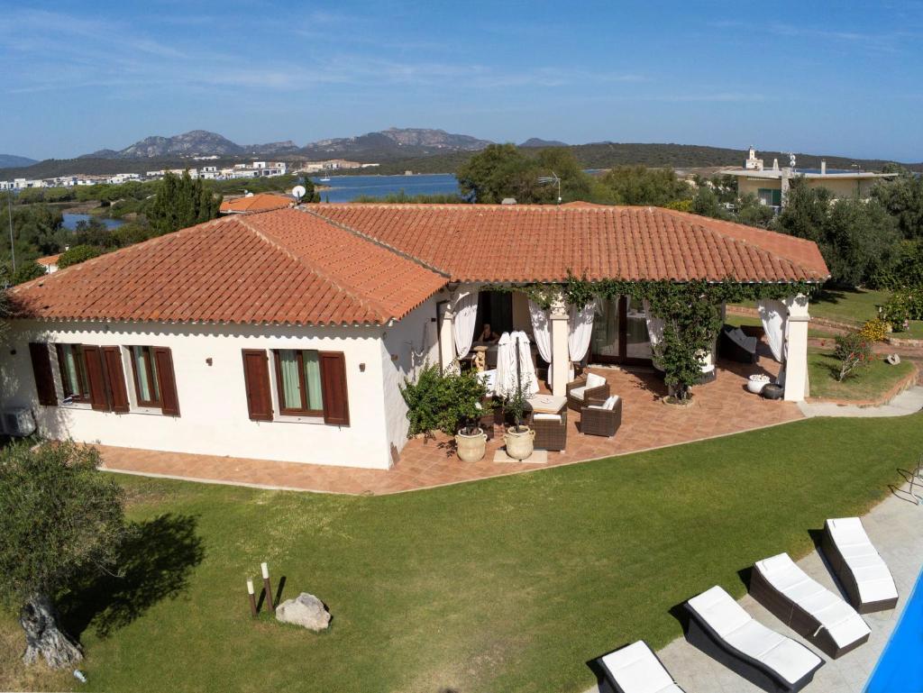 une maison blanche avec un toit rouge et des chaises blanches dans l'établissement Villa Nadine, à Murta Maria