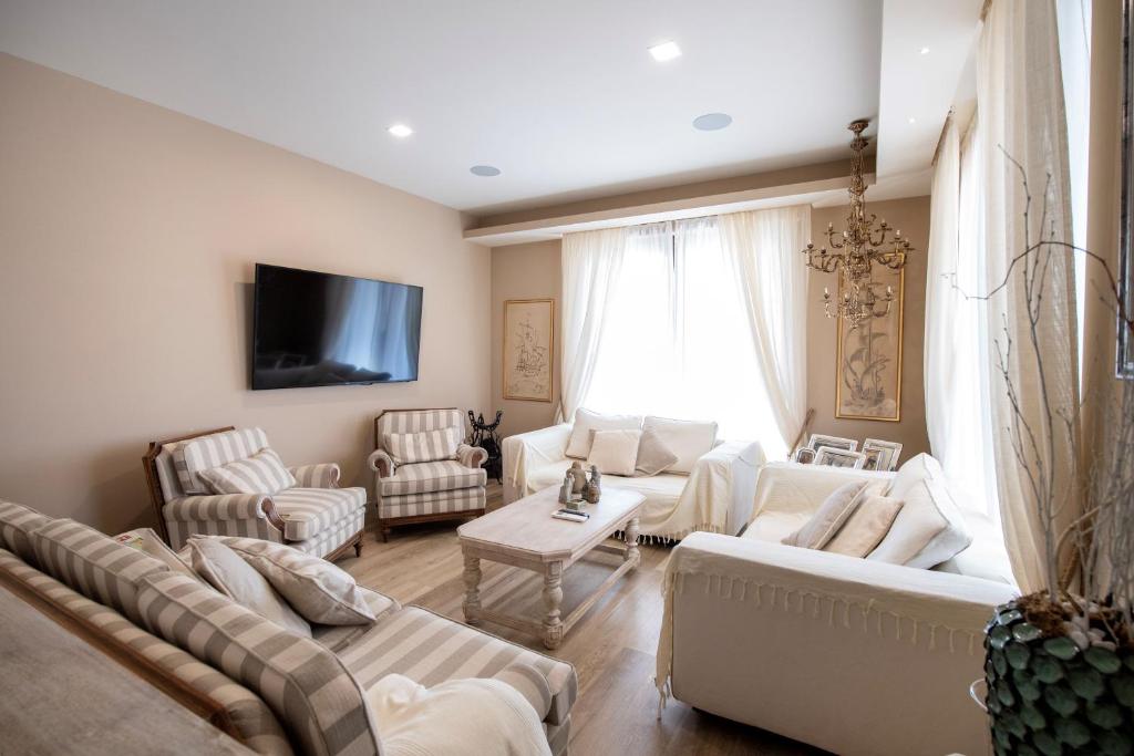 un salon avec des meubles blancs et une grande fenêtre dans l'établissement Villa Nadine, à Murta Maria