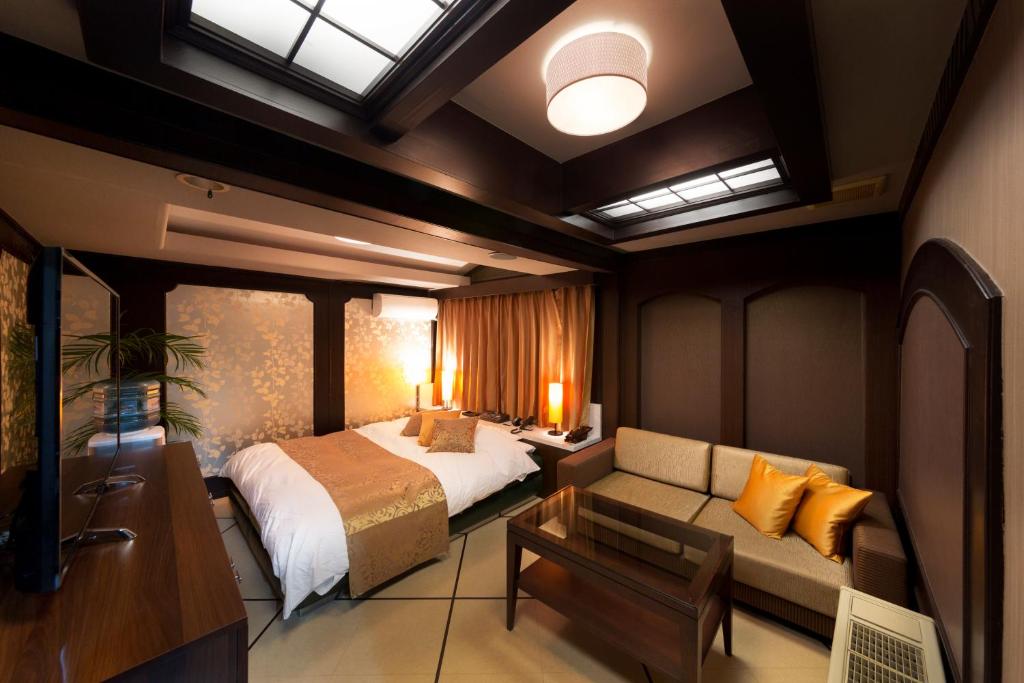 une chambre avec un lit et un canapé dans l'établissement Hotel Lotus Modern sakai -Adult Only, à Mimiharachō