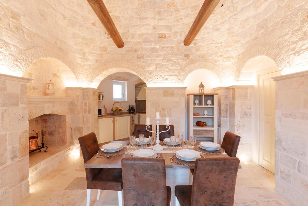 une salle à manger avec une table et des chaises en bois dans l'établissement Trulli Petrantiqua con piscina, à Locorotondo