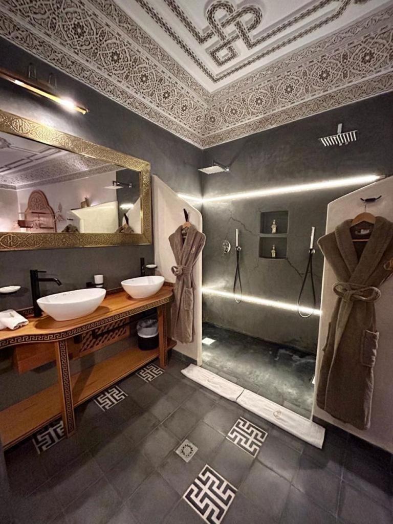 une salle de bain avec deux lavabos et un grand miroir dans l'établissement Riad Al Nubala, à Marrakech