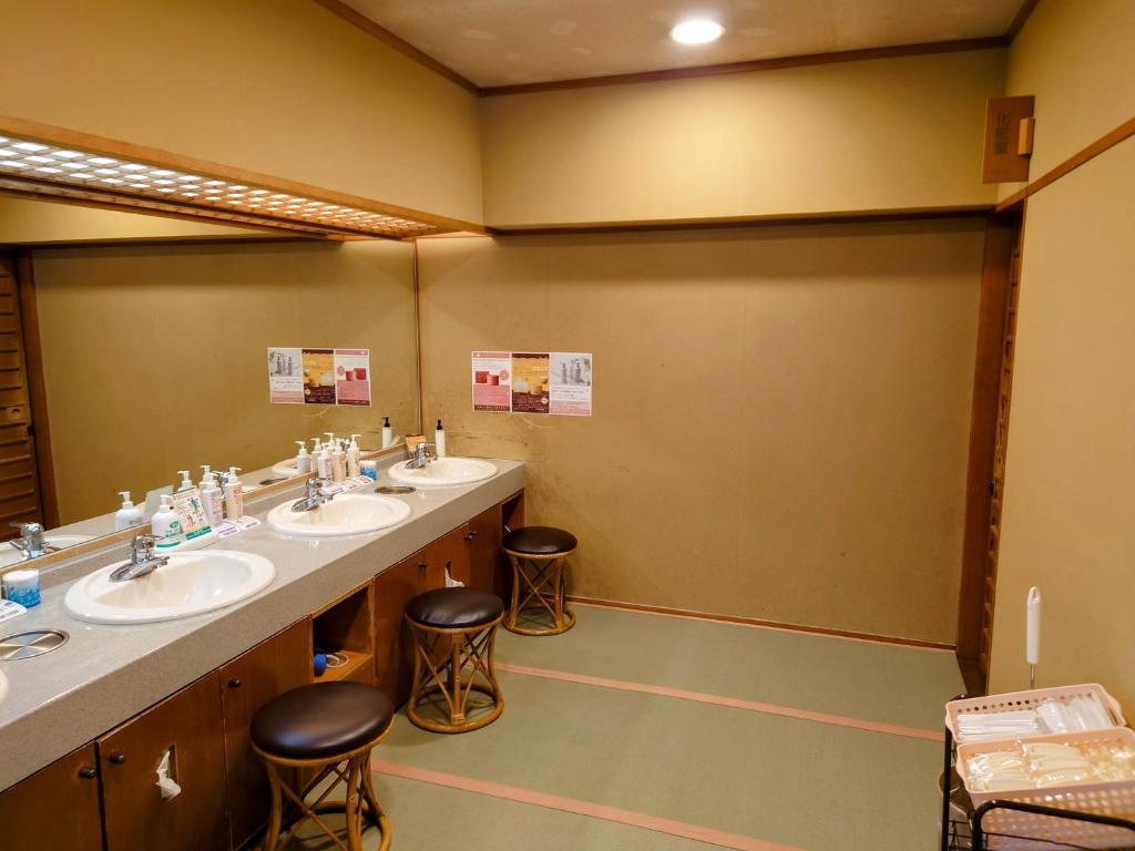 une salle de bain avec trois lavabos et deux miroirs dans l'établissement Itoen Hotel Asamanoyu, à Matsumoto