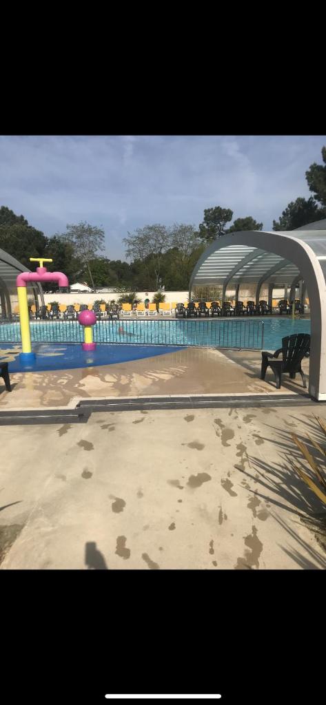 une piscine avec un parc aquatique en arrière-plan dans l'établissement Le bois dormant, à Saint-Jean-de-Monts