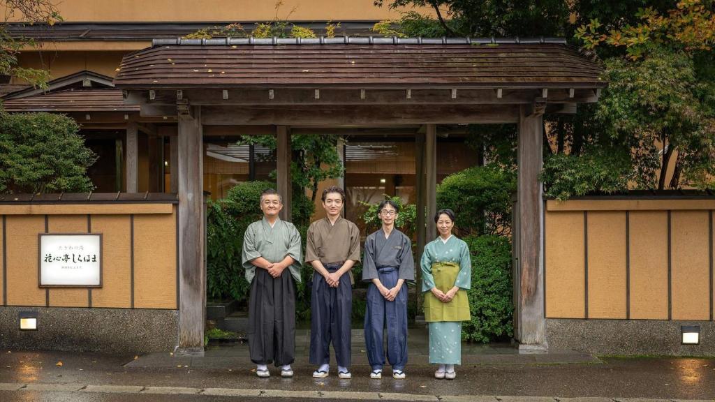 un groupe de personnes debout devant un bâtiment dans l'établissement Kashintei Shirahama, à Senboku