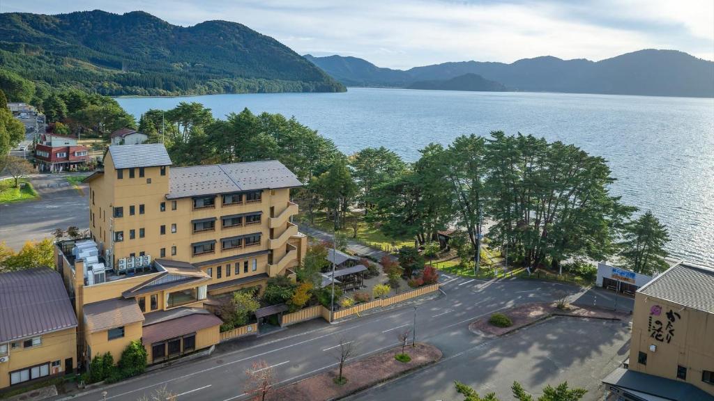 une vue aérienne d'un bâtiment à côté d'une masse d'eau dans l'établissement Kashintei Shirahama, à Senboku