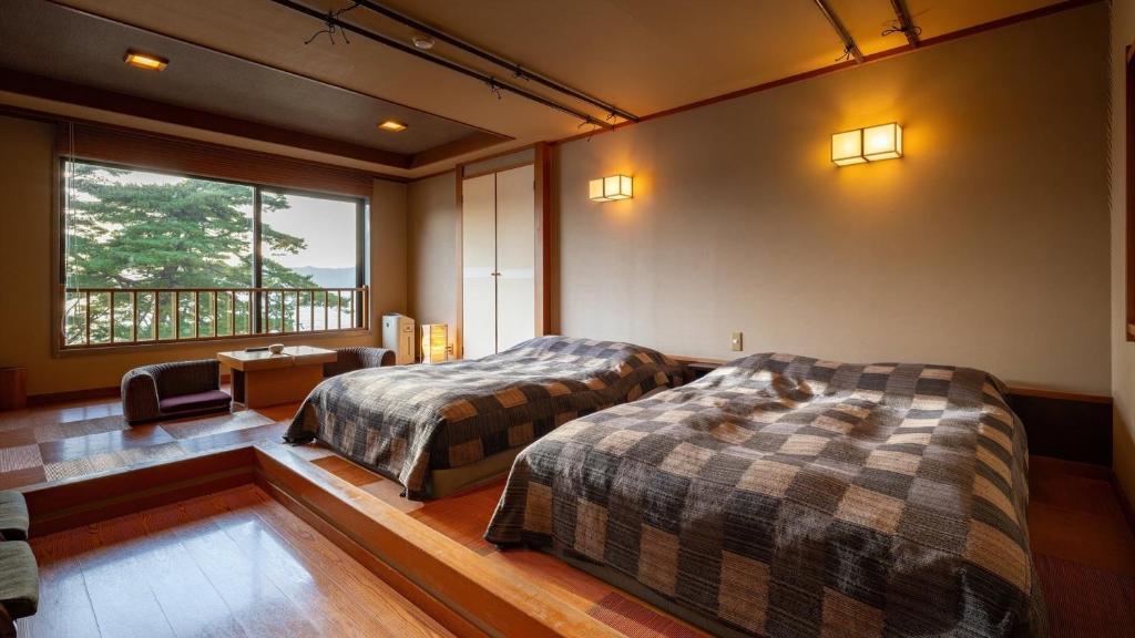 une chambre avec deux lits et un bureau et une fenêtre dans l'établissement Katakurinohana, à Senboku