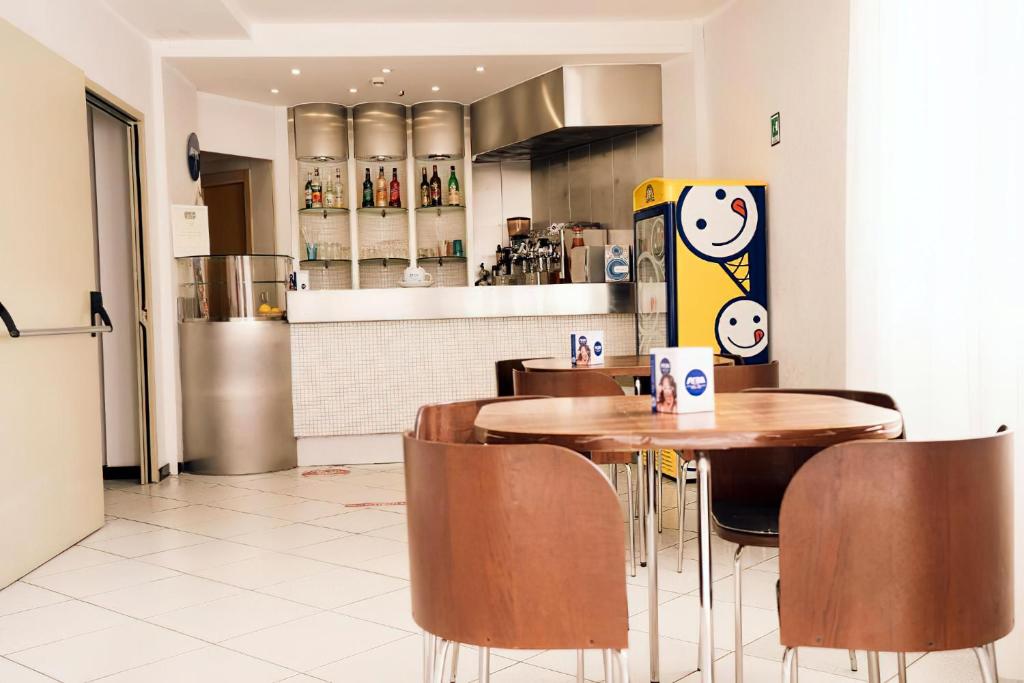 un restaurant avec des tables et des chaises et une cuisine dans l'établissement Gargano Hotel Helios, à Rodi Garganico