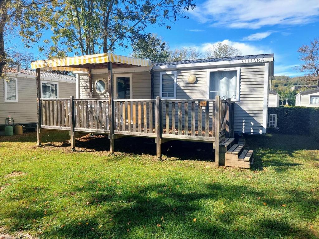 une petite maison avec un porche et une terrasse dans l'établissement Mobilhome 6 personnes camping 4*, à Châteauneuf-de-Galaure