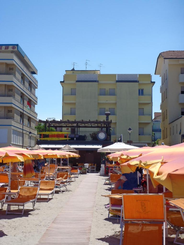 - un bouquet de chaises et de parasols sur une plage dans l'établissement Hotel Sandra, à Gatteo a Mare