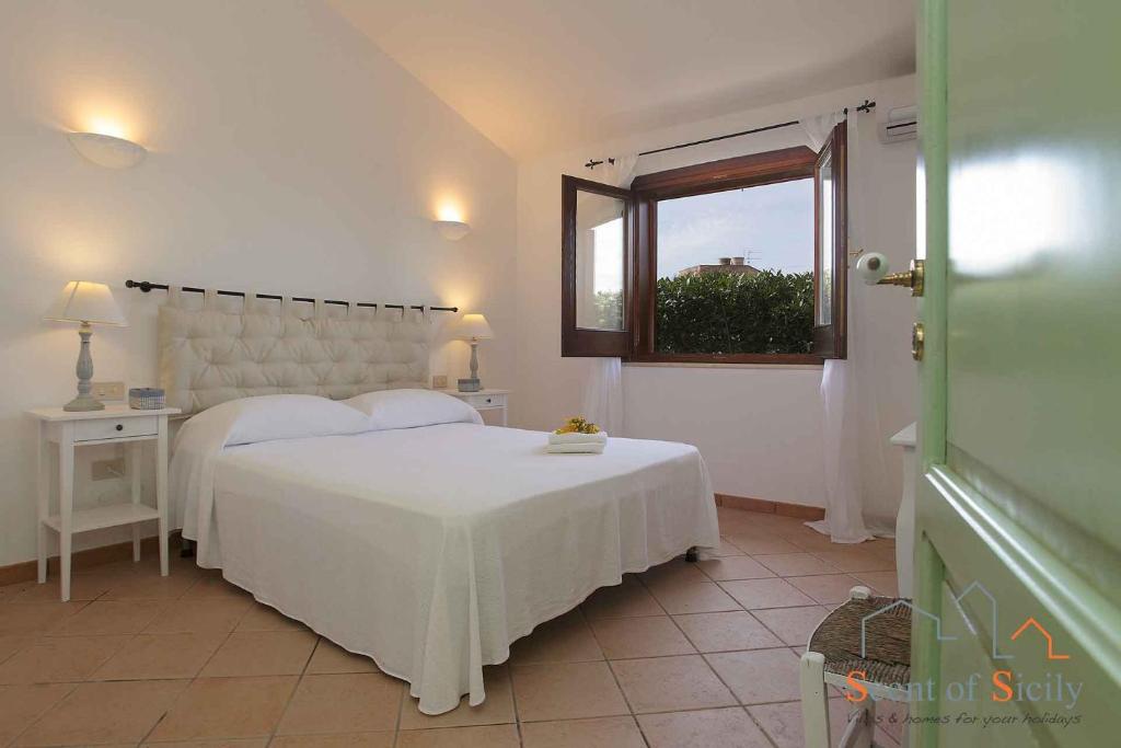 une chambre avec un lit blanc et une fenêtre dans l'établissement Villa Giò Sicily Holidays, à Marsala