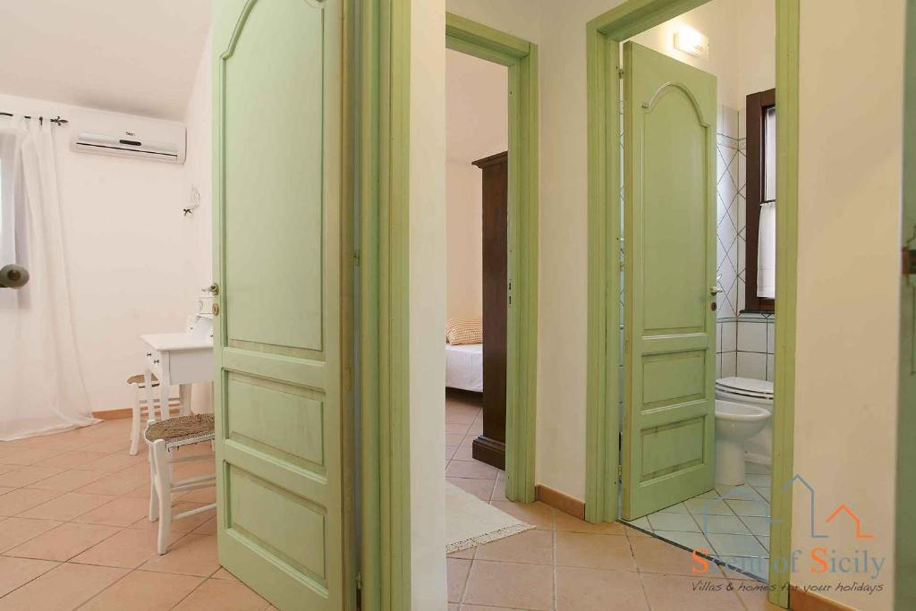 Cette chambre comprend des portes vertes et une salle de bains pourvue de toilettes. dans l'établissement Villa Giò Sicily Holidays, à Marsala