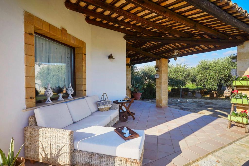 une terrasse avec un canapé blanc sous une pergola en bois dans l'établissement Villa Giò Sicily Holidays, à Marsala