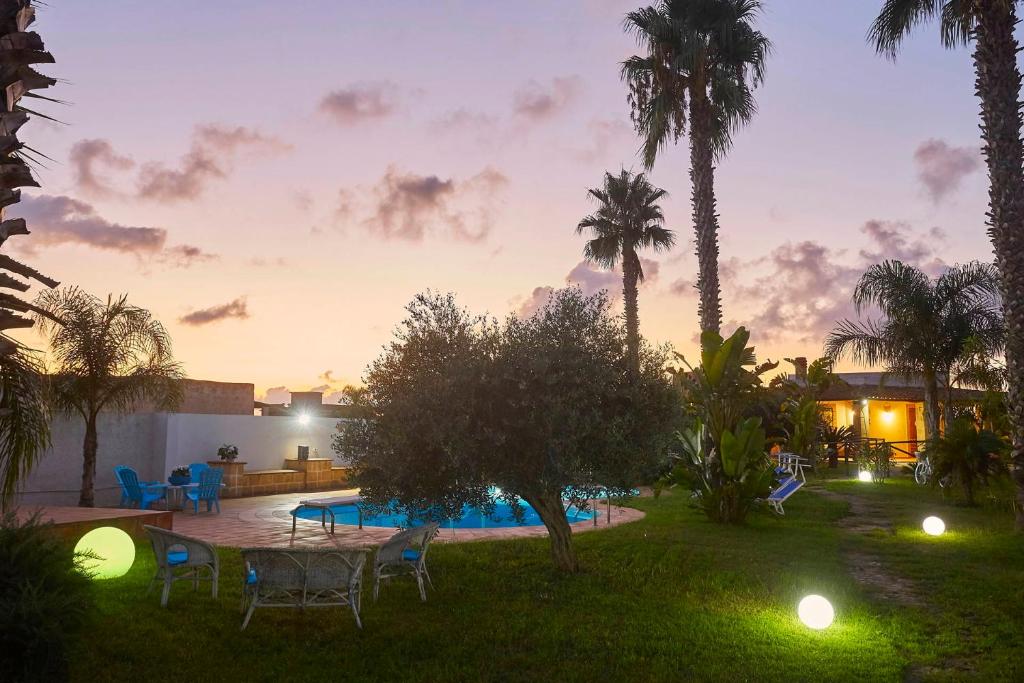 une cour arrière avec une table, des chaises et une piscine dans l'établissement Villa Giò Sicily Holidays, à Marsala