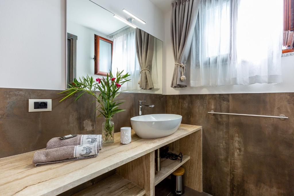une salle de bain avec un lavabo et un miroir dans l'établissement DOMUS VILLA LORY Castiadas Cala Sinzias beach with swimming pool, à Castiadas
