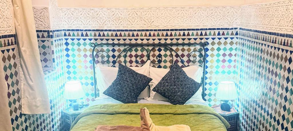 - un lit avec une tête de lit et des oreillers dans l'établissement Riad Essaoussan, à Marrakech