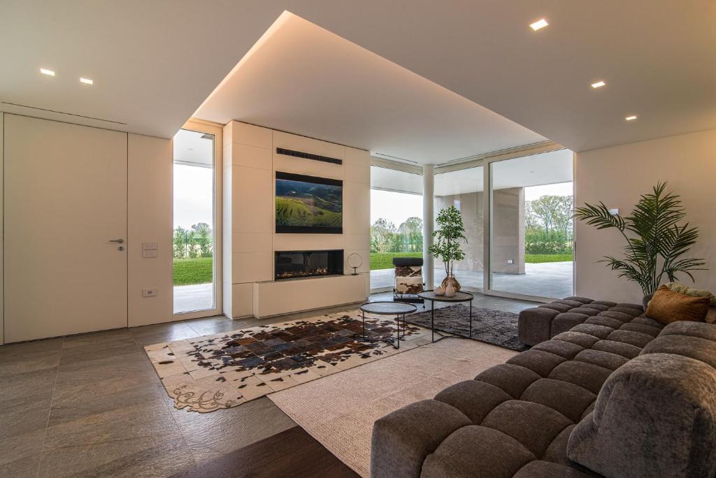 un salon avec un canapé et une cheminée dans l'établissement STIMAHome villa con piscina privata, à Veggiano