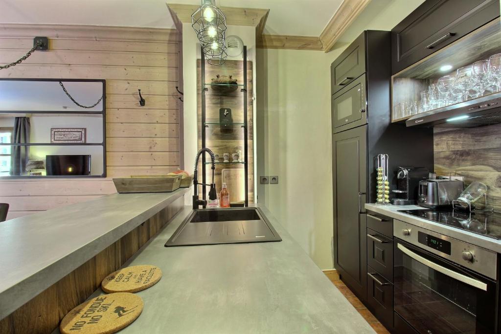 une cuisine avec un comptoir et un évier dans l'établissement Appartement T3 ARC 1950 skis aux pieds Sauna, Hammam, Jacuzzi, à Arc 1950