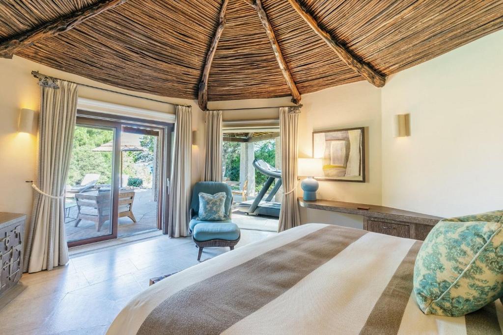 une chambre avec un lit et une chaise dans une pièce dans l'établissement Hotel Pitrizza, Costa Smeralda, à Porto Cervo 107 autres photos