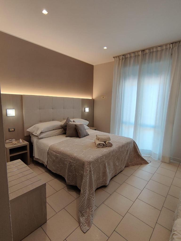 une chambre avec un lit et une grande fenêtre dans l'établissement Hotel Stefan Room & Breakfast, à Gatteo a Mare