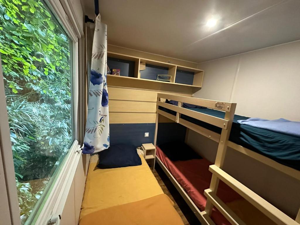 Cette petite chambre comprend des lits superposés et une fenêtre. dans l'établissement La maison du Sud, à Saint-Chéron
